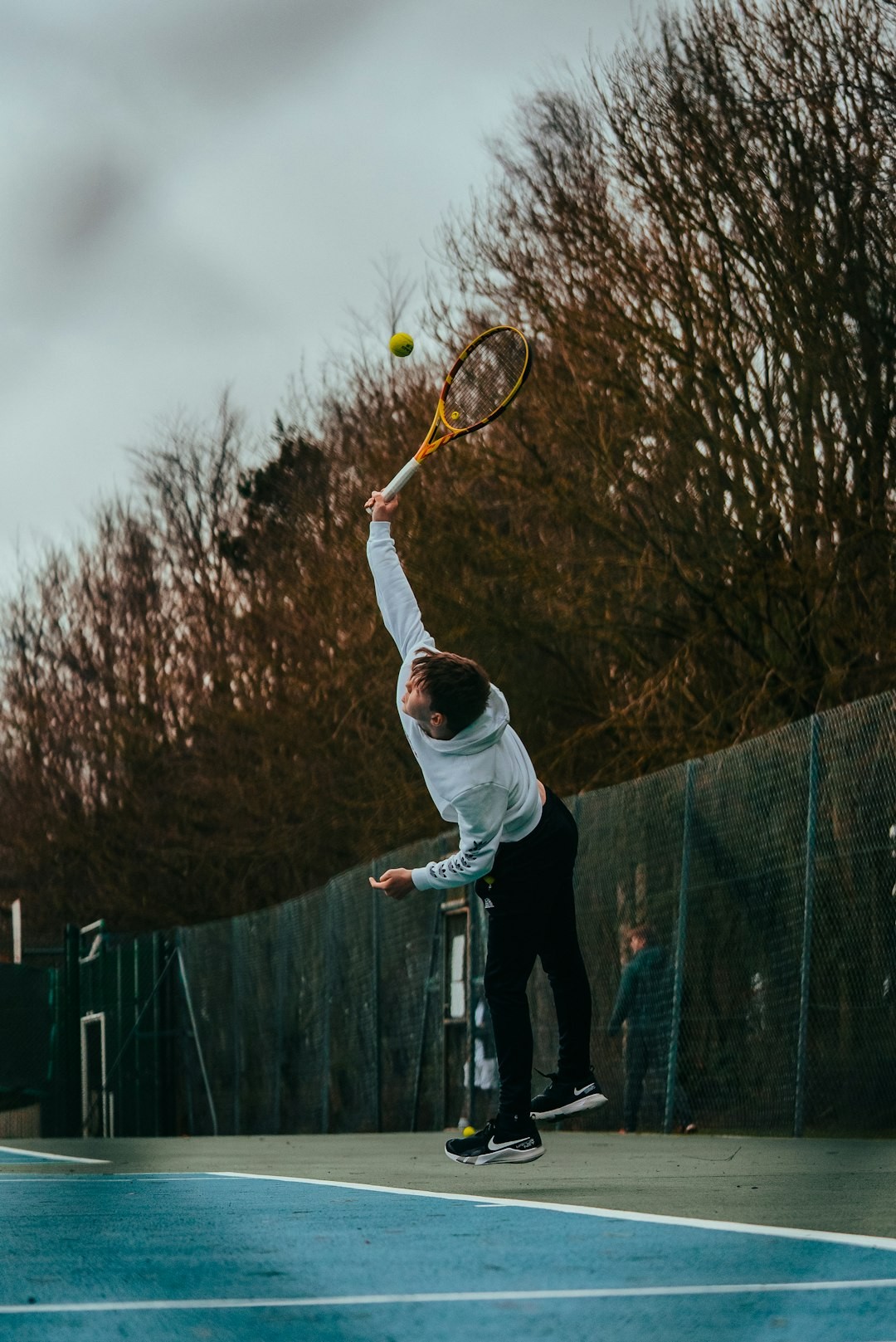 a man jumping up to hit a tennis ball